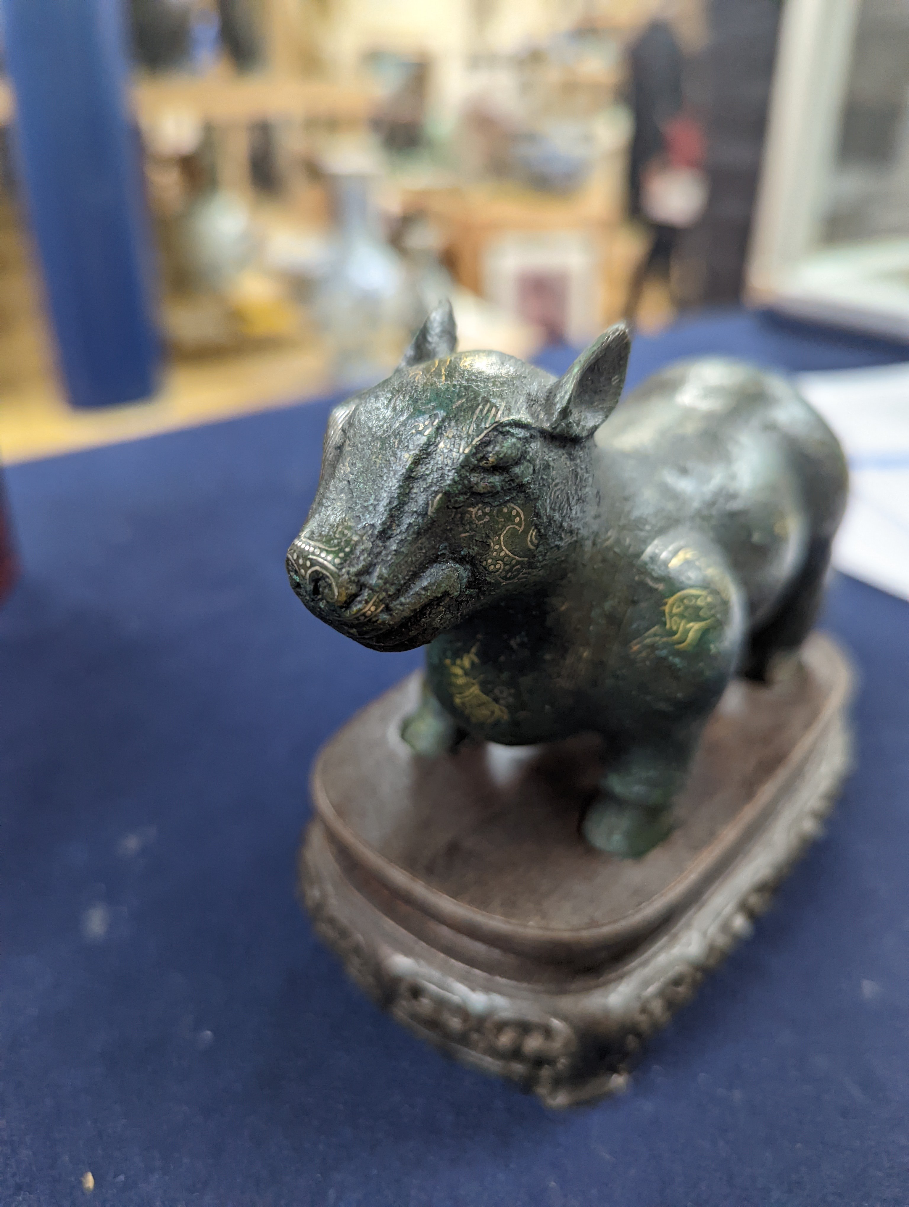 A Chinese gold and silver inlaid bronze figure of a tapir, Han dynasty or later, L. 12cm, excluding hardwood stand and fitted box